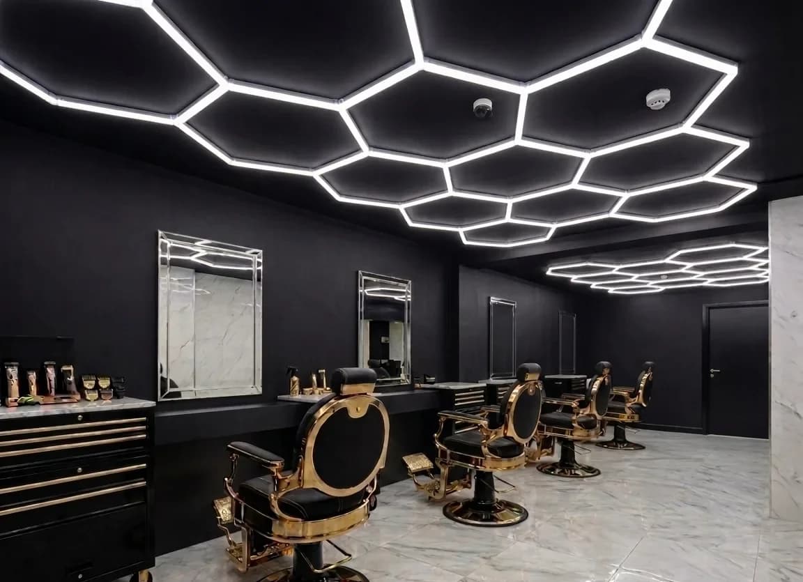 Gold barber chairs under hexagon ceiling lights at Golden Chair